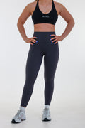 Model wearing Base Leggings in graphite grey, high-waisted with seamless waistband and light compression fit.
