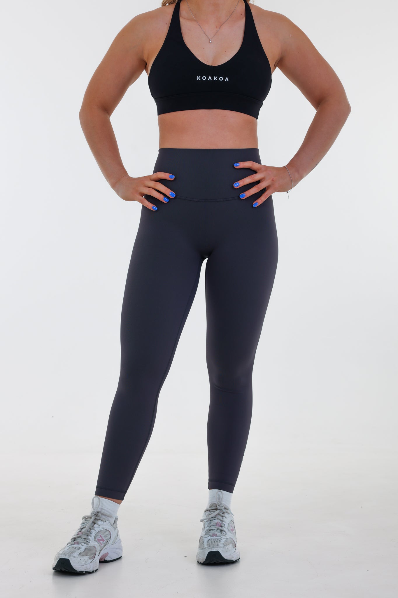 Model wearing Base Leggings in graphite grey, high-waisted with seamless waistband and light compression fit.